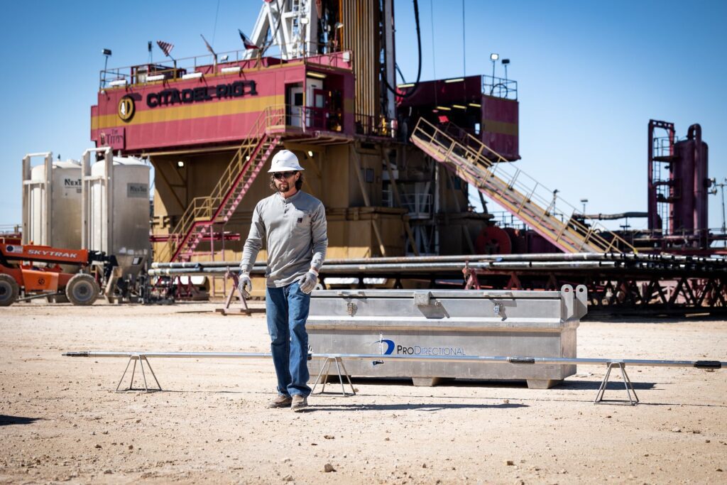 Man walking in front of drilling rig