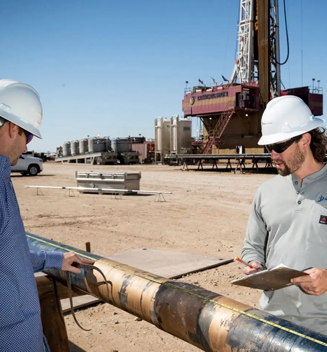 2 engineers on a drilling site measuring tool
