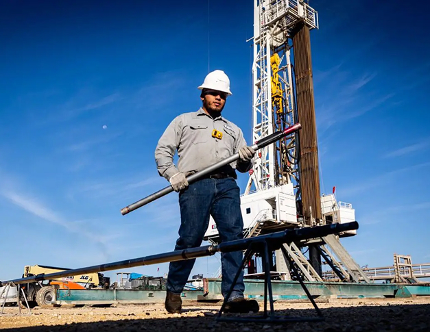 Directional drilling technician handling a downhole mud motor component on a drilling rig during ProPower motor operations.